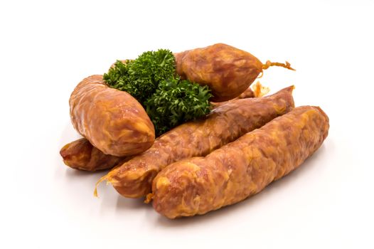 Smoked sausages on a white background with a sprig of parsley gaumaise sausages