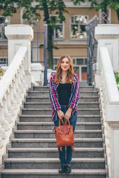 Young woman standing on the old staircase