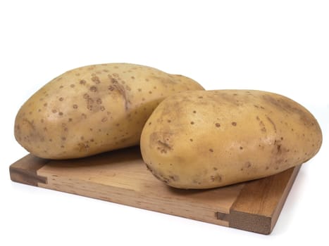 The close up of fresh organic potato vegetable on small wooden board on white background.