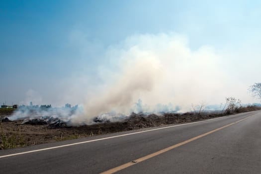 Dense dust and smoke from burning stubble in agricultural areas along the road after harvest