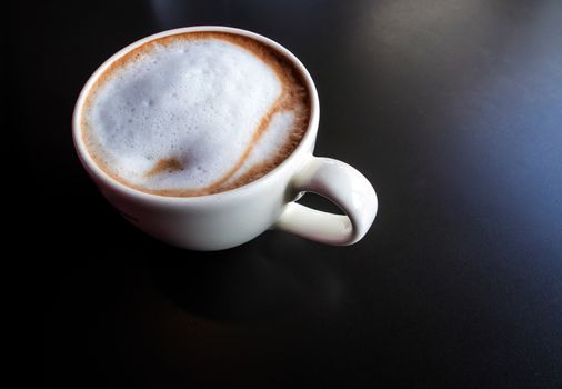 Hot milk coffee and soft froth in white ceramic cup