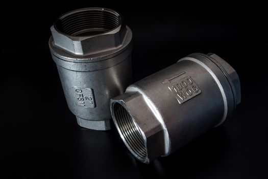 Stainless steel check valve on black background