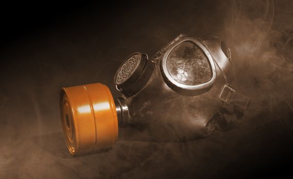 Vintage gasmask isolated on black background - Smoke in the room - Orange filter