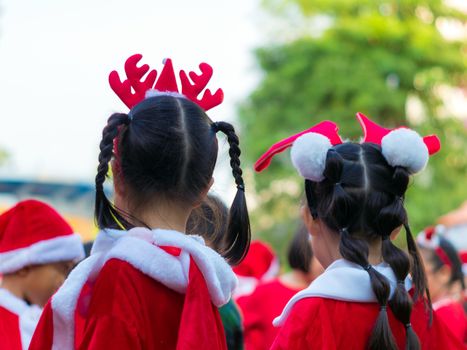 Girls in red theme costume in Christmas party of elementary school