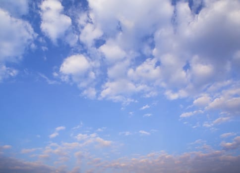 White fluffy clouds in the blue sky with morning light from the sunrise