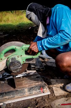 Male worker cutting steel with a cutting machine