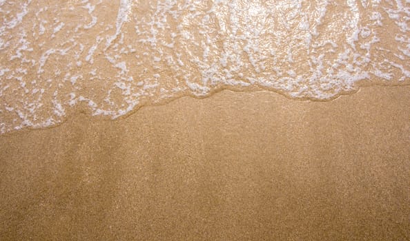 White bubble of Sea wave on fine sand at the beach