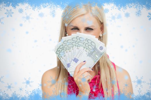 Beauty holding 100 euros banknotes against snow flake frame in blue