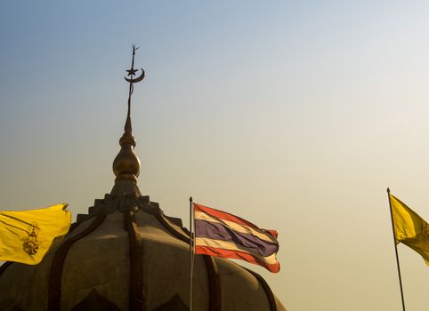 Thai flag and the flag of the king in front of the mosque building with evening sky