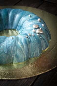 Mousse cake decorated in marine style covered with blue mirror glaze and silver decoration.