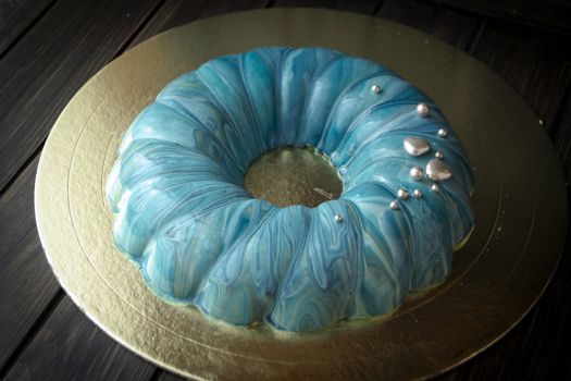blue berry modern mousse cake, covered with a turquoise mirror glaze with sea effect.