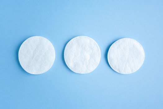 Organic cotton pads on blue background, cosmetics and make-up remover, hygiene and skincare. Close-Up Of Cotton Pads Over Blue Background