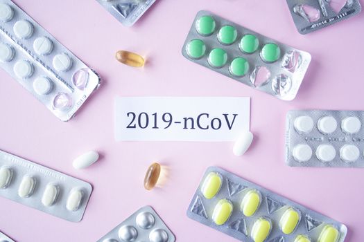 The inscription quote 2019 ncov on a pink background with many clusters of pills and pills. Coronavirus treatment concept. Medicines, vaccine for the virus. Antibiotics