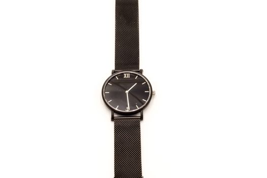 Classic black analog wristwatch on white background, close-up.