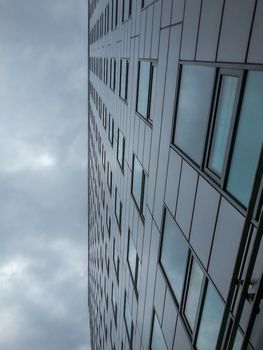 Look up to the clouds reflecting in corporate building