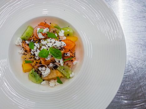 Colorful fruity salad with kiwi oranges basil and cottage cheese