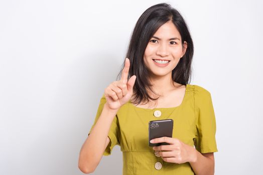 Portrait Asian beautiful happy young woman standing smile holding using mobile smart phone her show finger touch something looking to camera, shoot the photo in a studio on a white background