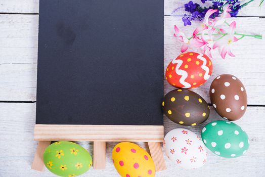 Easter eggs top view on white wooden background and have board work space board for use