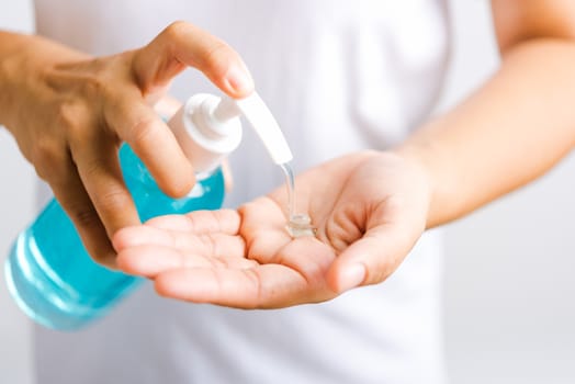 Closeup Hand Asian young woman applying pump dispenser sanitizer alcohol gel on hand wash cleaning, hygiene prevention COVID-19 or coronavirus protection concept, isolated on white background