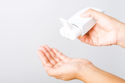 Closeup Hand Asian young woman applying drop dispenser sanitizer alcohol gel on hand wash cleaning, hygiene prevention COVID-19 or coronavirus protection concept, isolated on white background