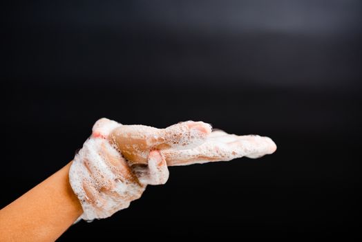 Closeup body care Asian young woman washing hands with soap have foam, hygiene prevention COVID-19 or coronavirus protection concept, isolated on black background