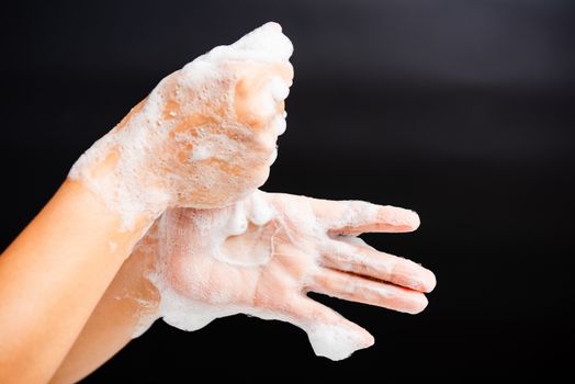 Closeup body care Asian young woman washing hands with soap have foam, hygiene prevention COVID-19 or coronavirus protection concept, isolated on black background