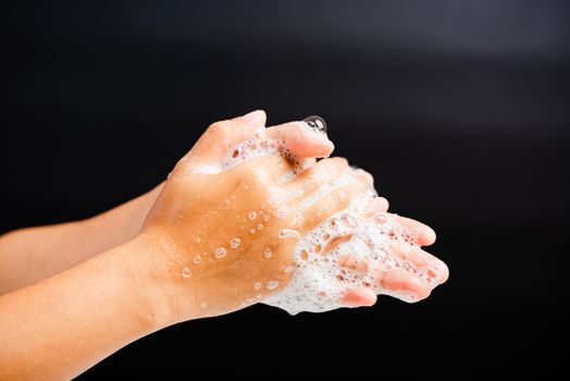 Closeup body care Asian young woman washing hands with soap have foam, hygiene prevention COVID-19 or coronavirus protection concept, isolated on black background