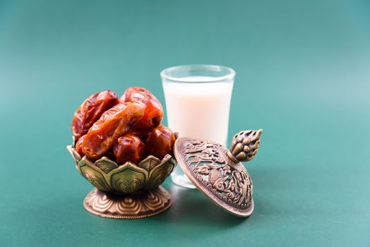 Ramadan, Dates in golden bowl, Milk, arabian Aladdin golden lamp vintage style on black green background