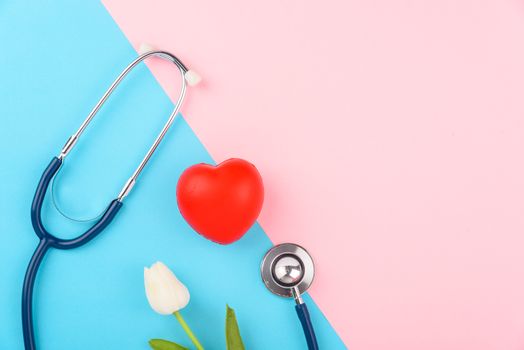 Doctor's Day concept, flat lay top view, stethoscope with red heart on pink blue background, diagnosis of heart disease with copy space for text