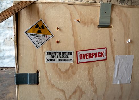 Radiation warning sign on the Hazardous materials transport label Class 7 at the wooden box package in the container of transport truck