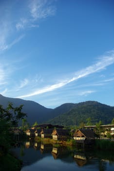 In the morning light small huts beside the lake and the mountain view 