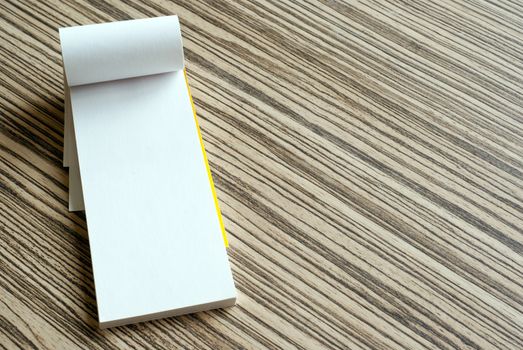 Blank white paper page of writing pad on wooden background