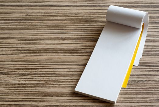 Blank white paper page of writing pad on wooden background