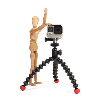 Wooden dummy standing trying to make a video or photo, isolated on white