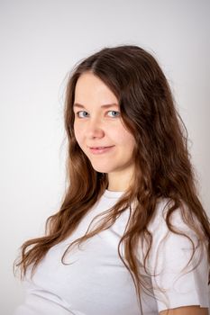 The young beautiful pregnant woman experiences strong emotions on a white background.