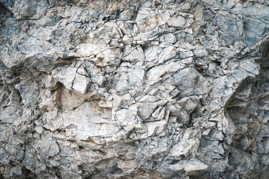 background or texture cracks on a block of gray white limestone