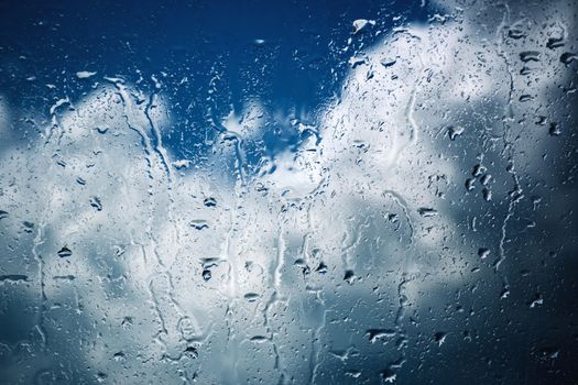 seasonal background Dark clouds on a rainy glass