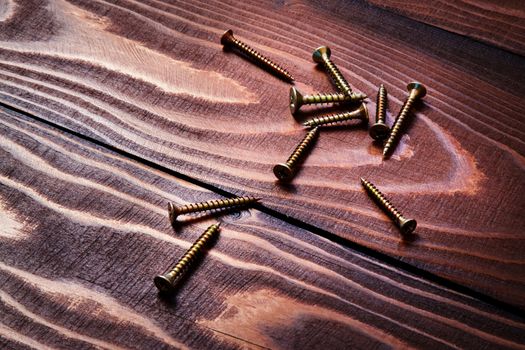 background screws scattered on an old wooden table