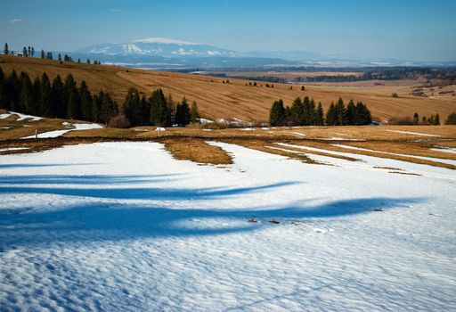 season nature background spring snowy landscape with a meadow