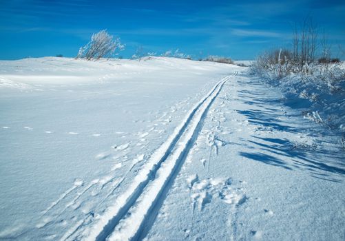 seasonal landscape background snowy plain with a ski track