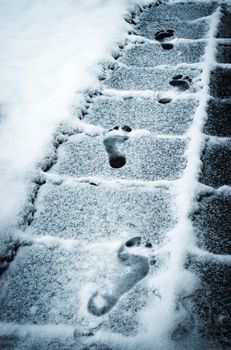 seasonal background footprints feet on the snowy sidewalk