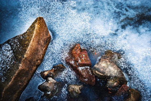 nature abstract background stones frozen in ice on the river