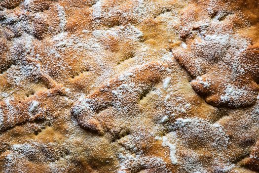 background or texture an uneven surface of cake sprinkled with sugar