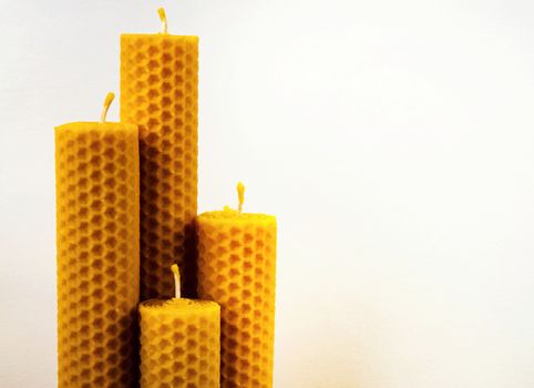 composition of four beeswax candles on a white background