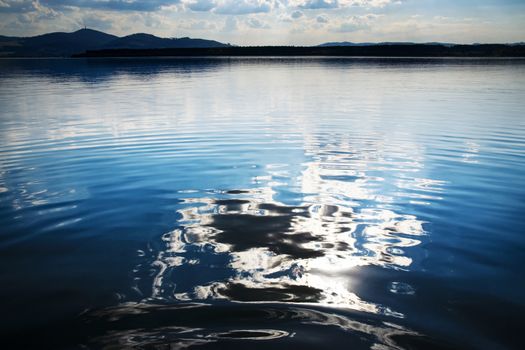 nature background abstract reflection of a cloud on a lake water surface