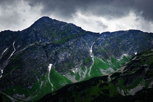 landscape background dark sky over a rocky peak in the mountains