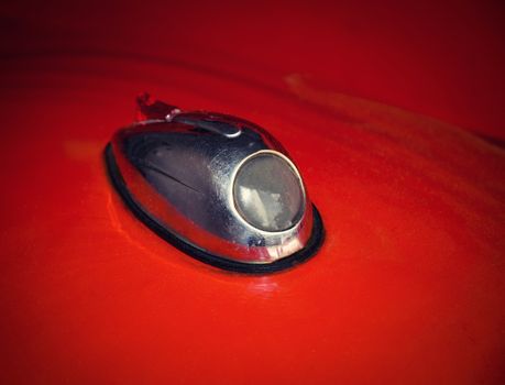 background detail of a light on an old red car