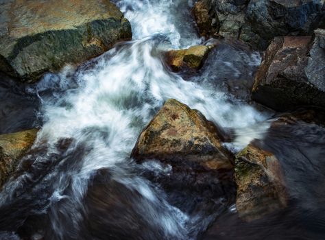 abstract nature background blurred water flowing between the stones