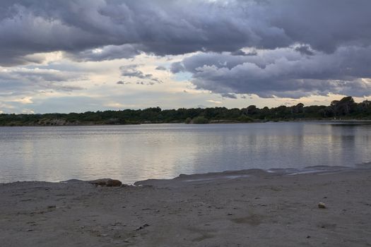 Still water lake after the storm, dramatic clouds, blue, reflections