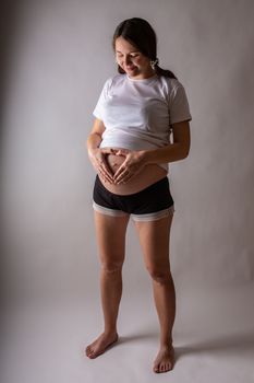 Pregnant woman touching belly close-up